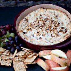 Creamy apple cinnamon dip topped with chopped nuts served with apple slices, grapes, and graham crackers.