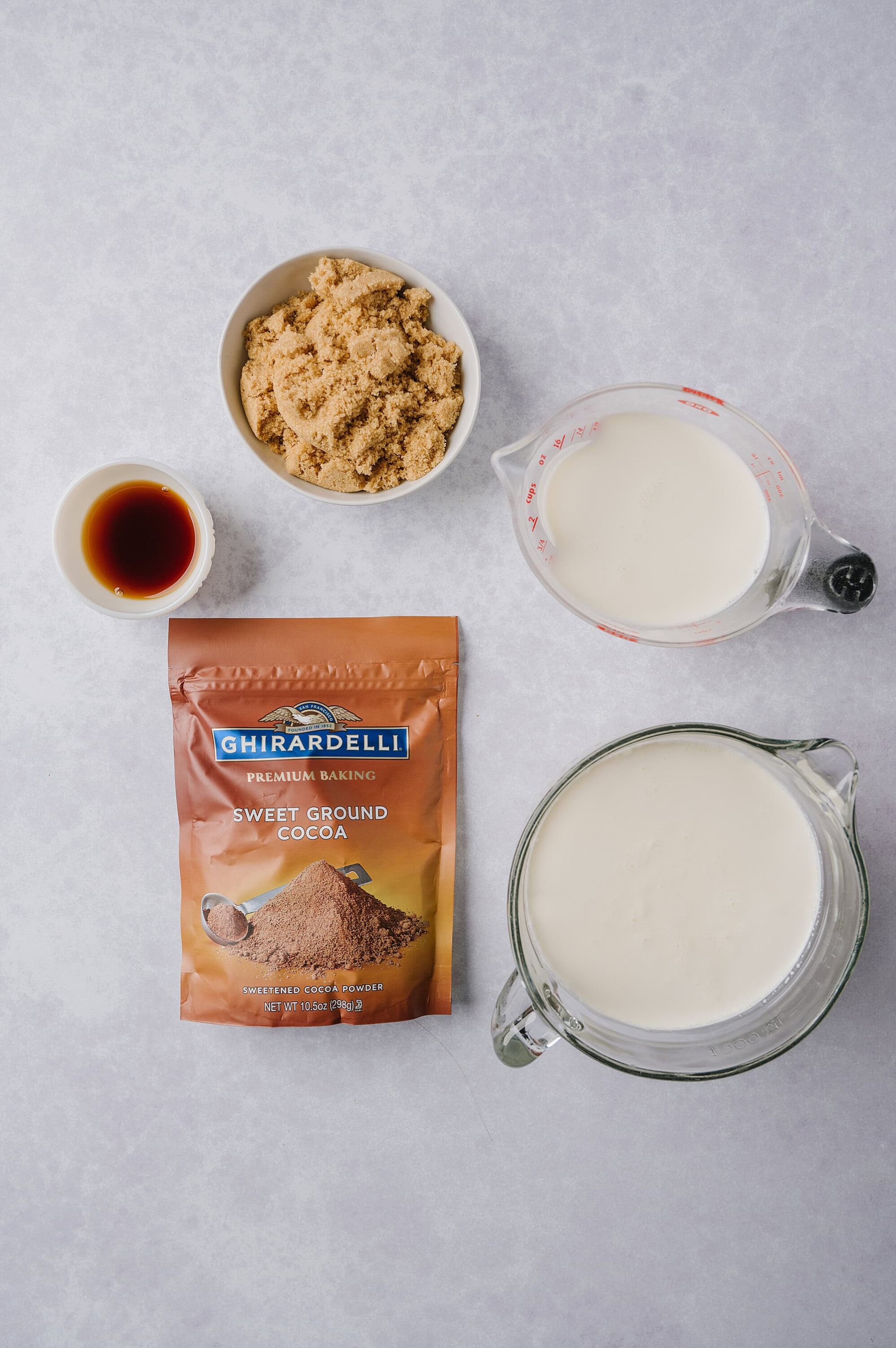 Sweet ground cocoa powder, milk, vanilla extract, light brown sugar, and baking ingredients for chocolate baking.