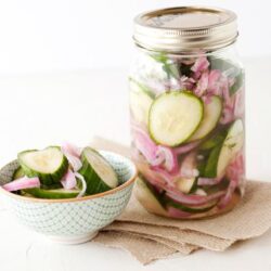 Crisp homemade cucumber onion pickles in a glass jar and bowl, fresh and tangy for easy homemade relish recipes.