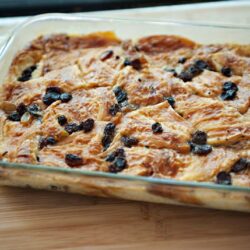 Creamy baked casserole with blueberries in a glass baking dish.