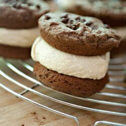Rich chocolate cookies with creamy vanilla filling on a cooling rack, perfect for homemade dessert recipes.