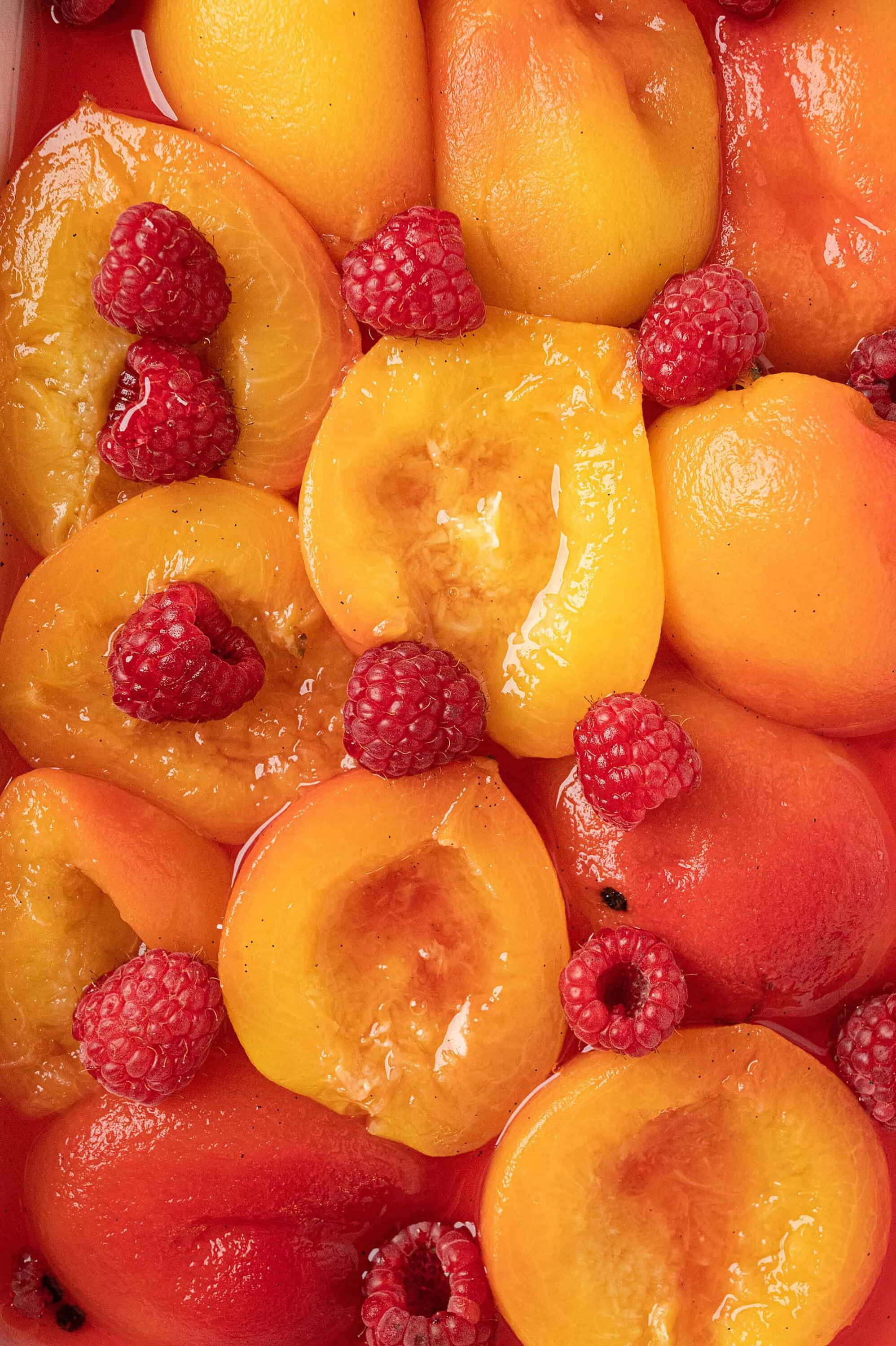 Juicy peach slices and ripe raspberries in a refreshing fruit salad. Perfect for summer desserts and healthy snacks.