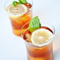 Refreshing iced tea with lemon slices and mint leaves.