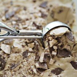 Chunks of chocolate and cookie dough in a baking dish, ready for baking or serving.