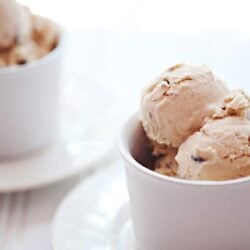 Creamy homemade ice cream scoops in white bowls, perfect for dessert recipes.