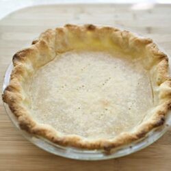 Flaky pie crust in a glass pie dish ready for filling.