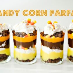 Rich candy corn parfait layered with chocolate, vanilla, and candy toppings in clear glasses.