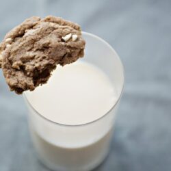 Oatmeal cookie with milk in glass.