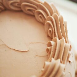 Buttercream frosting piped on cake, close-up baking detail.