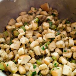 Crunchy seasoned croutons with chopped green onions in a mixing bowl.