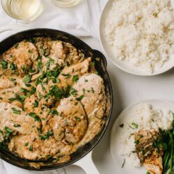 Creamy mushroom chicken skillet with garlic and herbs. Served with fluffy white rice and green beans for a delicious meal.