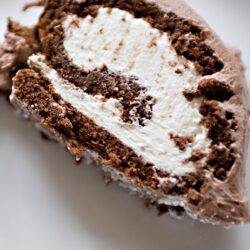 Rich chocolate roll cake with creamy vanilla filling, perfect for desserts and special occasions.
