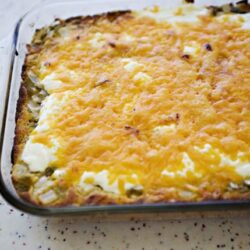 Cheesy casserole baked in glass dish with melted cheese topping and golden crust.