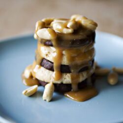 Butterfinger candy layered dessert on blue plate, caramel sauce and nuts, delicious treat, Baked Bree recipe.