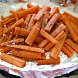 Roasted seasoned carrots on aluminum foil.