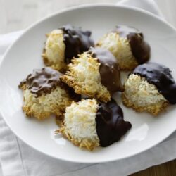 Coconut macaroons with chocolate drizzle on a white plate, homemade dessert recipe from Baked Bree.