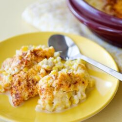 Creamy baked macaroni and cheese with a golden breadcrumb topping on a yellow plate.