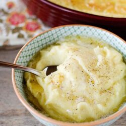 Creamy mashed potatoes with butter and pepper in a patterned bowl for comfort food.