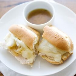 Creamy turkey and melted cheese sandwich on sandwich bun with gravy dipping sauce.