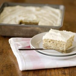 Creamy homemade cake with fluffy frosting served on a white plate.