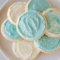 Delicate sugar cookies with blue and white icing and sprinkles, perfect for holidays or special occasions.