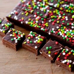 Butterfingers chocolate fudge with colorful sprinkles on wooden surface, Baked Bree recipe, homemade holiday treat, decadent chocolate dessert, festive baking.