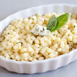 Creamy corn casserole with fresh basil and blue cheese topping, perfect for comfort food and side dishes.