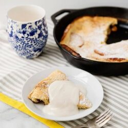 Fluffy apple pie with vanilla ice cream served on a white plate.