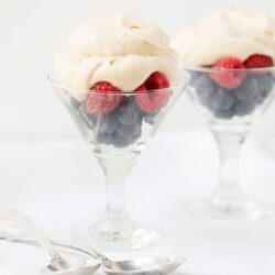 Fresh berry parfait with whipped cream in elegant glassware for a light dessert.