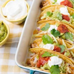 Delicious beef tacos with fresh toppings in a white baking dish.