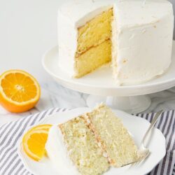 Fluffy lemon birthday cake with white frosting and orange slices for celebration.