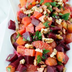 Vibrant beet and citrus salad with walnuts and fresh herbs, perfect for healthy summer meals.