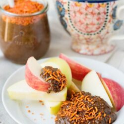 Baked Bree apple slices with caramel dip, topped with orange sprinkles, served with a cup of coffee and hot cocoa.