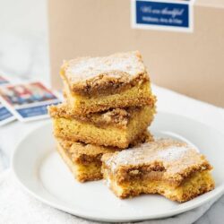 Butterscotch blondie bars with a sweet caramel flavor sitting on a white plate.