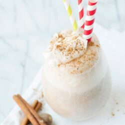 Creamy spiced homemade eggnog served in a glass with cinnamon and colorful straws, perfect for holiday celebrations.