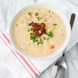 Creamy chicken and vegetable chowder topped with bacon and green onions, perfect for comforting homemade soup.