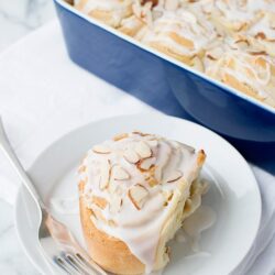 Butter mochi cake with coconut cream glaze on a white plate, baked by Baked Bree.