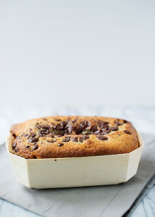 Golden chocolate chip cookie cake in baking dish on marble surface, home baking, dessert, chocolate cookies.
