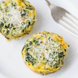 Scrambled egg muffins with spinach and cheese on a white plate.