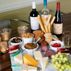 Assorted cheese, meats, and wine for a festive charcuterie board.