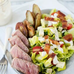 Juicy steak salad with bacon, cherry tomatoes, and crisp lettuce. Perfect for a hearty, flavorful meal.