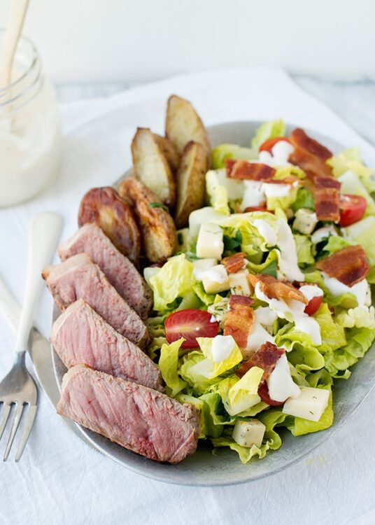Juicy steak salad with bacon, cherry tomatoes, and crisp lettuce. Perfect for a hearty, flavorful meal.