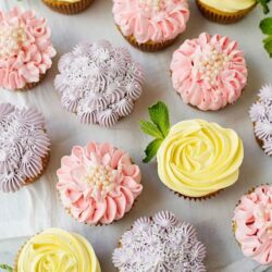 Delicious decorated cupcakes with pastel pink, purple, and yellow frosting, perfect for celebrations and parties.