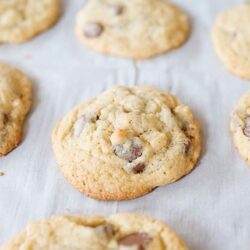 Chocolate chip cookies fresh out of the oven on a baking sheet, showcasing homemade cookie recipe.