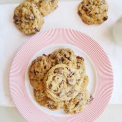 Homemade chocolate chip cookies on a red-rimmed plate, fresh baked, perfect for snacking or dessert.