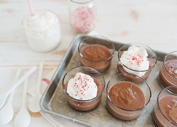 Creamy chocolate mousse served in glass cups with whipped cream and sprinkles, perfect for dessert.