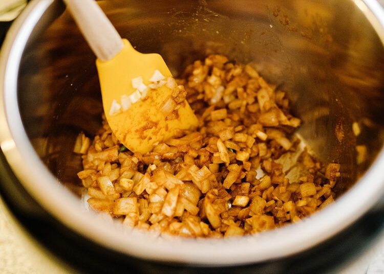 Slow cooker sautéed onions and garlic in a butter sauce for flavorful dishes.