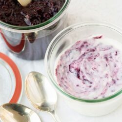 Creamy berry yogurt smoothies with swirled berry topping and fresh fruit. Perfect for a healthy breakfast or snack.