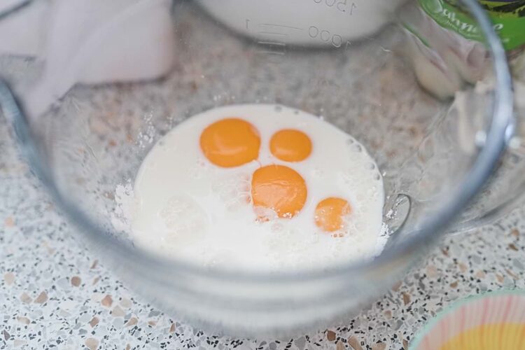 Whisked eggs in a glass mixing bowl for baking recipes.
