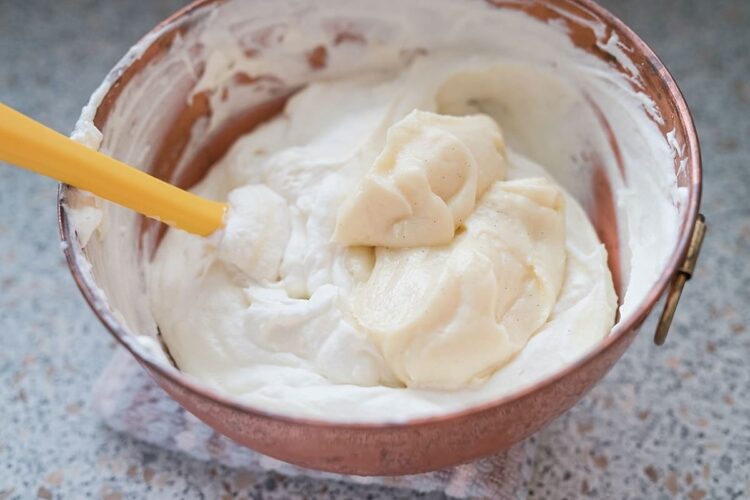 Creamy homemade vanilla ice cream mixture in a copper ice cream maker bowl.